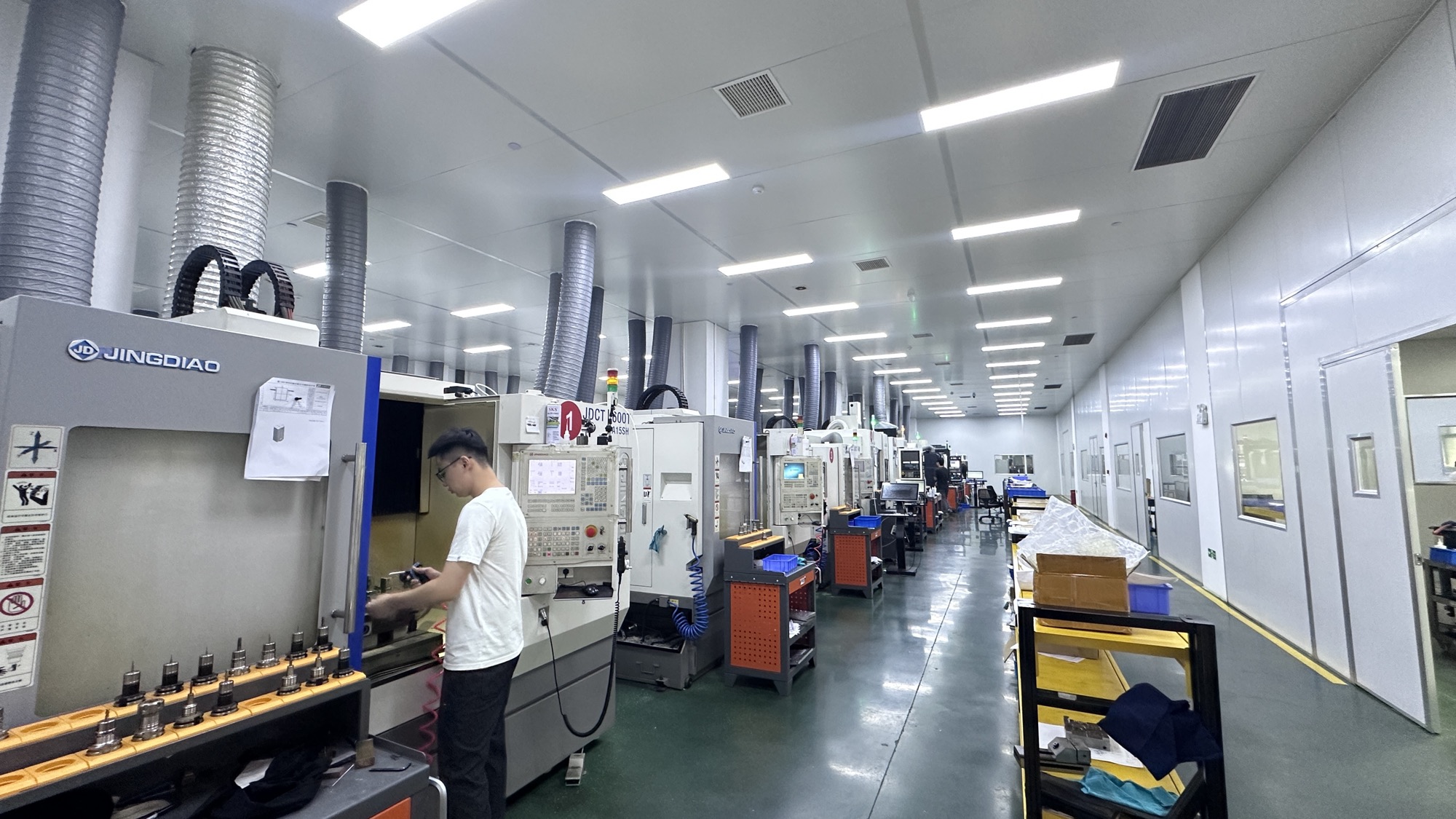Hongye precision CNC machining factory floor with rows of machining centers and an operator in Xiamen, China