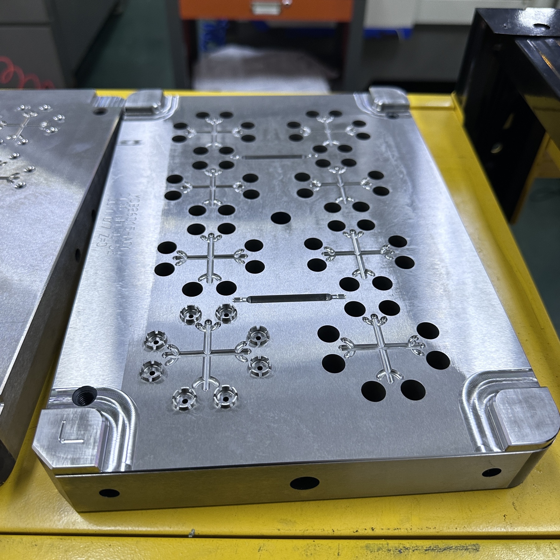 Close-up of a precision-machined multi-cavity mold plate with repeated small cavities, holes and runner features